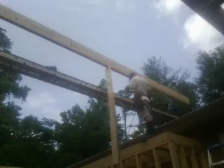 Carpenter setting a ridge beam over a new addition frame — Ice Dam Removal by Roofing Brothers in Sioux City